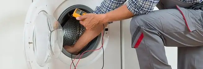 Dryer repair technician inspecting and repairing a clothes dryer in Sarasota, FL