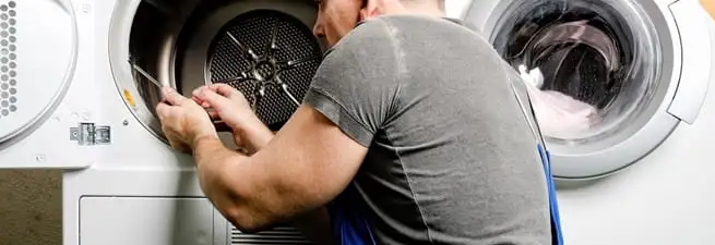 Dryer repair technician fixing a clothes dryer drum in Sarasota, FL