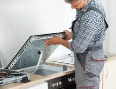 Appliance repair technician installing a built-in cooktop in Sarasota, FL