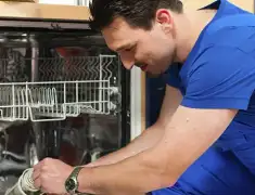 Dishwasher repair technician inspecting and servicing an open dishwasher in Sarasota, FL