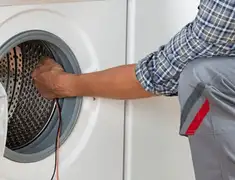 Dryer repair technician diagnosing and servicing a clothes dryer in Sarasota, FL