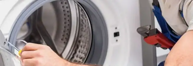 Appliance technician repairing a clothes dryer drum and internal parts in Sarasota, FL
