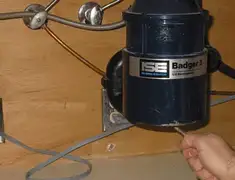 Garbage disposal repair technician tightening the mounting ring under a sink in Sarasota, FL