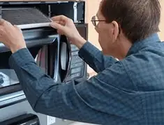 Appliance repair technician replacing a microwave vent filter in Sarasota, FL