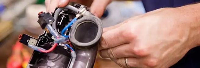 Vacuum repair technician reconnecting wiring and components in Sarasota, FL
