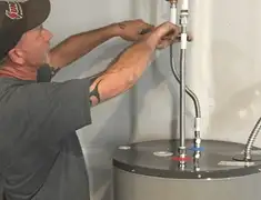Water heater repair technician tightening supply line connections in Sarasota, FL