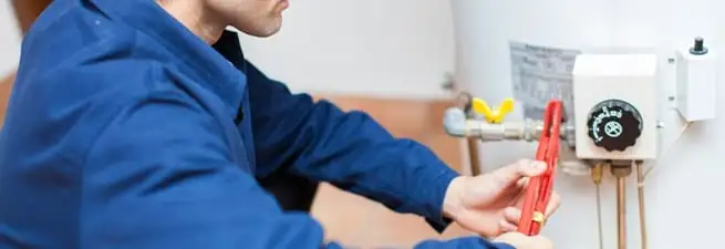 Water heater repair technician adjusting the temperature control and gas valve in Sarasota, FL
